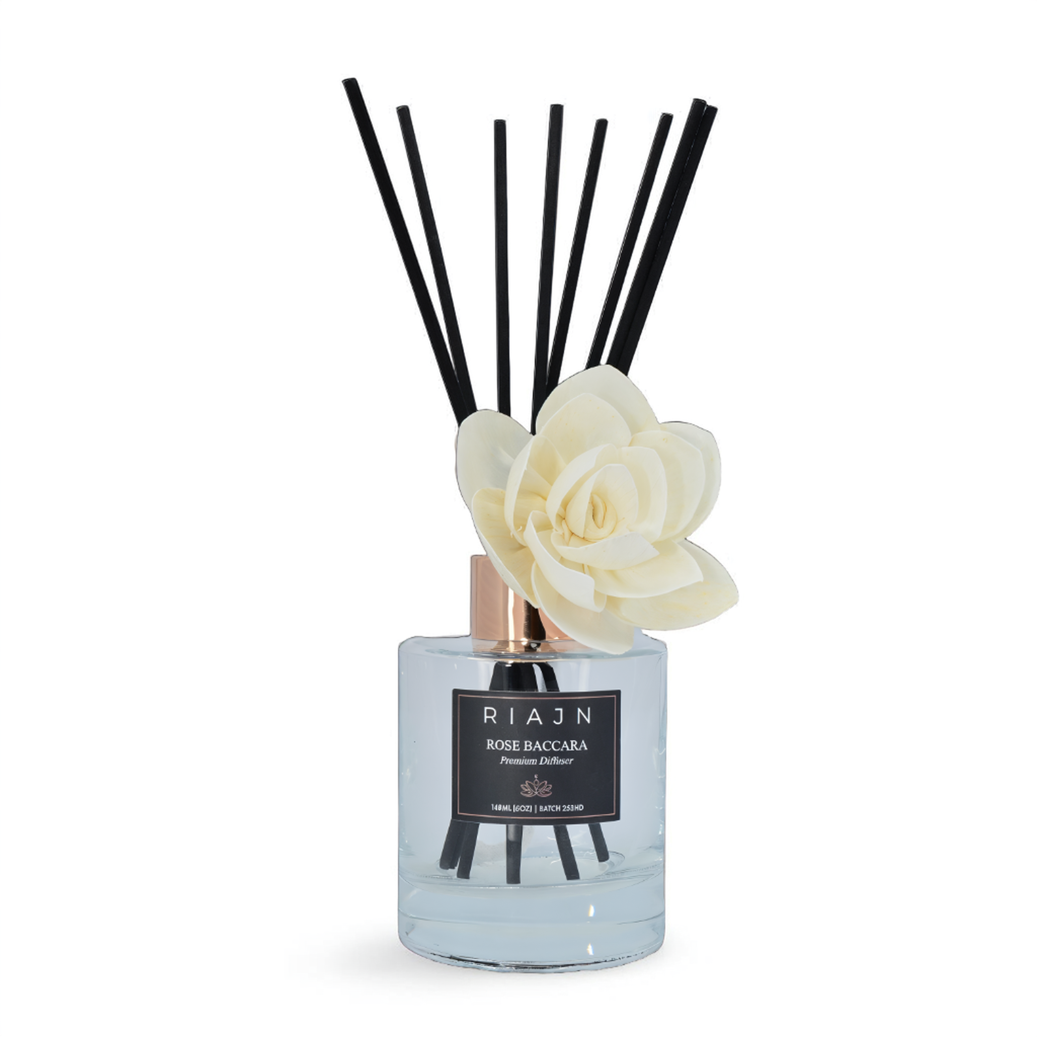 RIAJN rose baccara clear diffuser bottle with black reeds and white reed flower sticking out of the bottle on a white background.