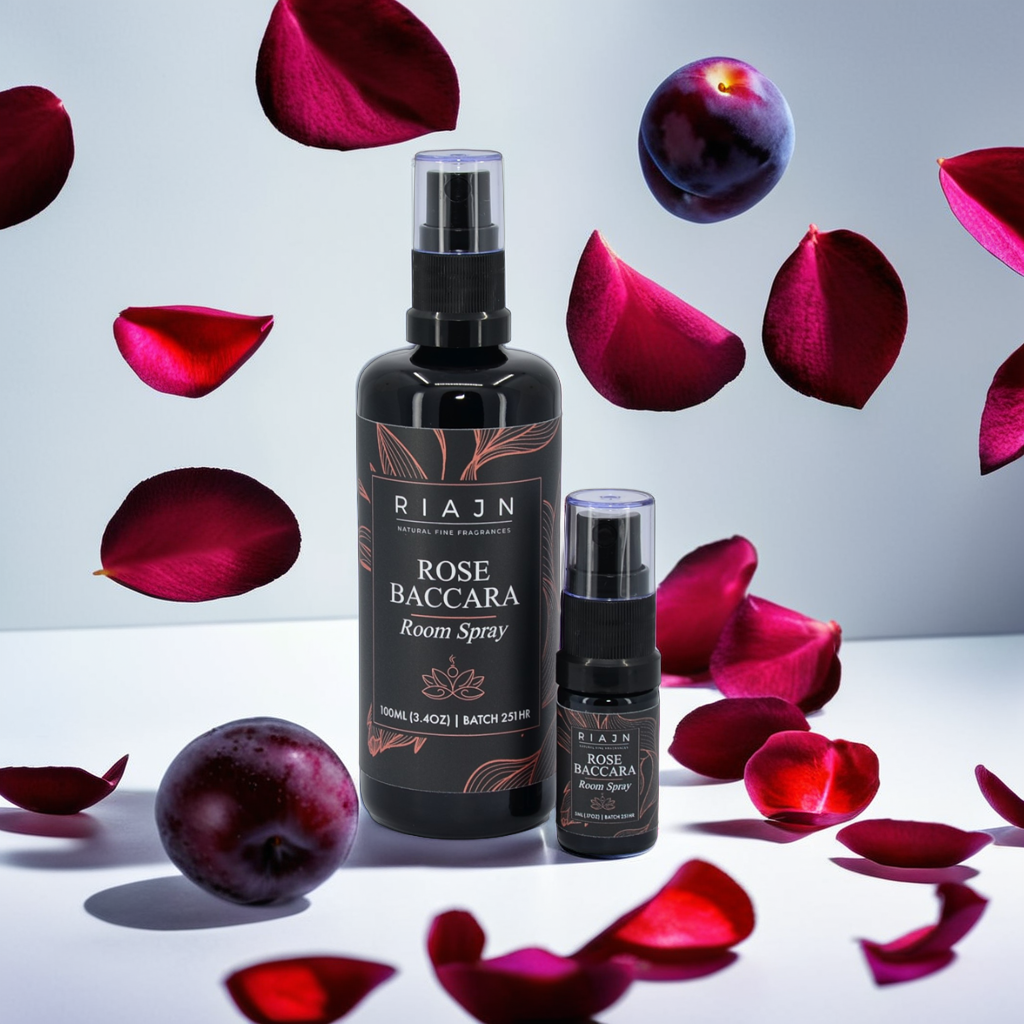 RIAJN Rose Baccara Room Spray bottles in a white room with falling dark rose pedals and plums with soft shadows. Top rose scented home freshener.
