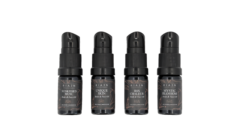 Four black spray bottles with labels on a white background. RIAJN body & face serum sample set.