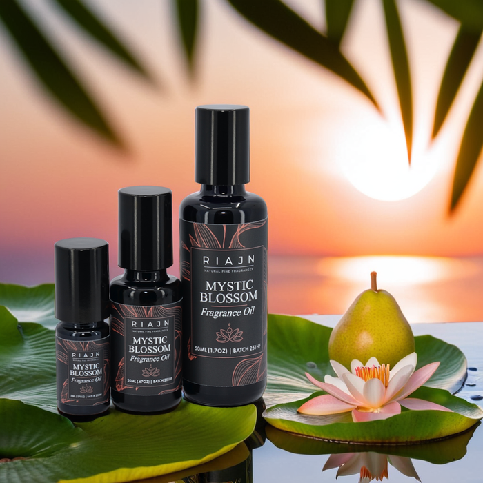 Three RIAJN Mystic Blossom Fragrance Oil bottles sitting on lily pads in a pond near water lilies with the sunset in the background