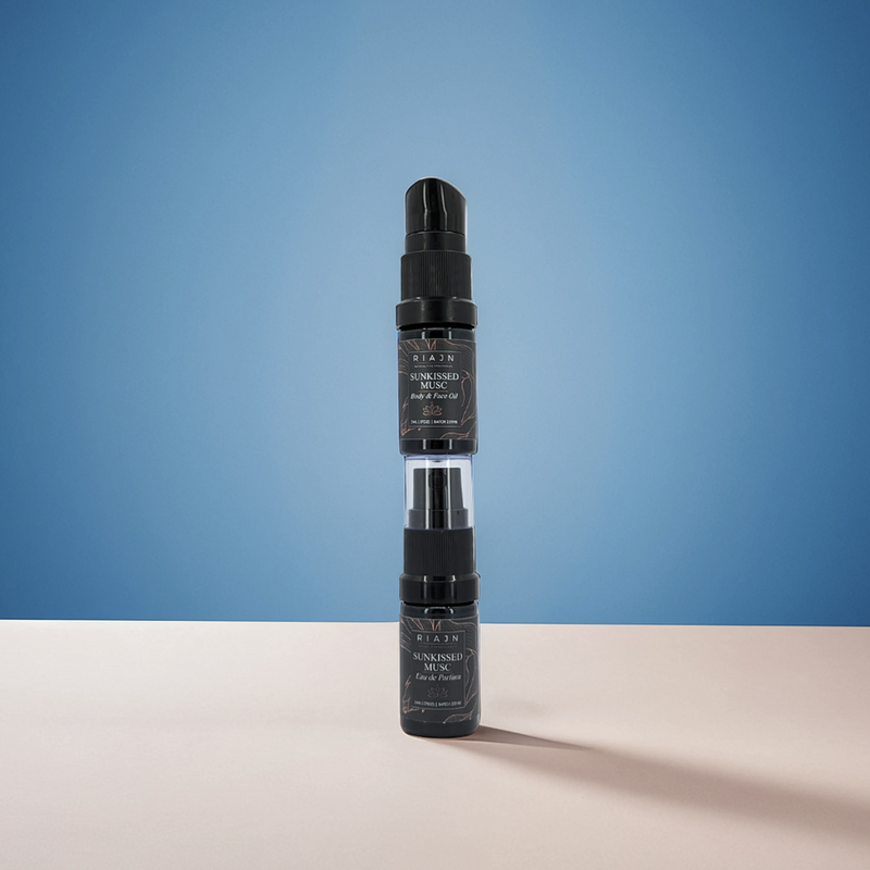 Two stacked black spray bottles on  a blue and beige gradient background