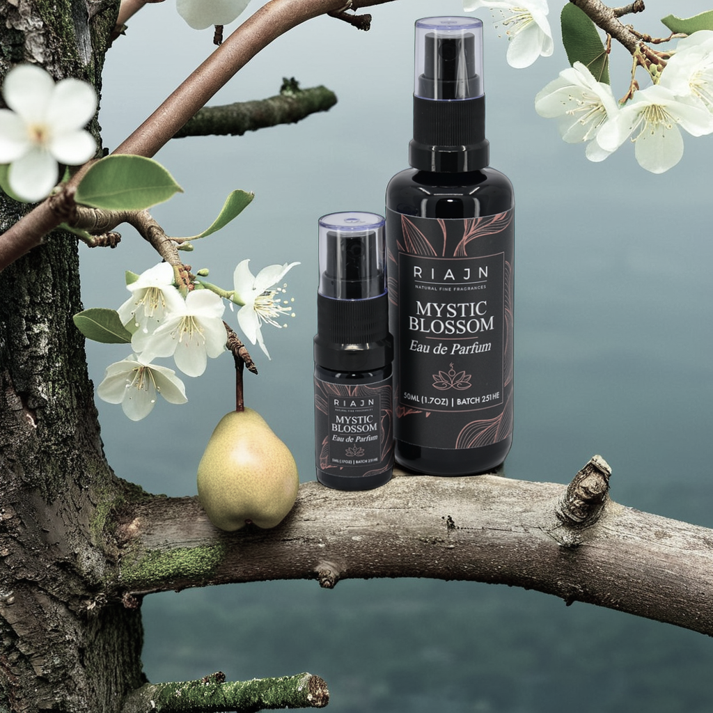 Riaan Mystic Blossom Eau de Parfum bottles on a branch with flowers and a pear.