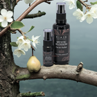 Riaan Mystic Blossom Eau de Parfum bottles on a branch with flowers and a pear.
