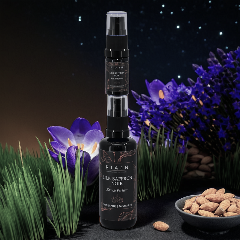 Bottle of Riajan Silk Saffron Noir fragrance with flowers and almonds on a dark background